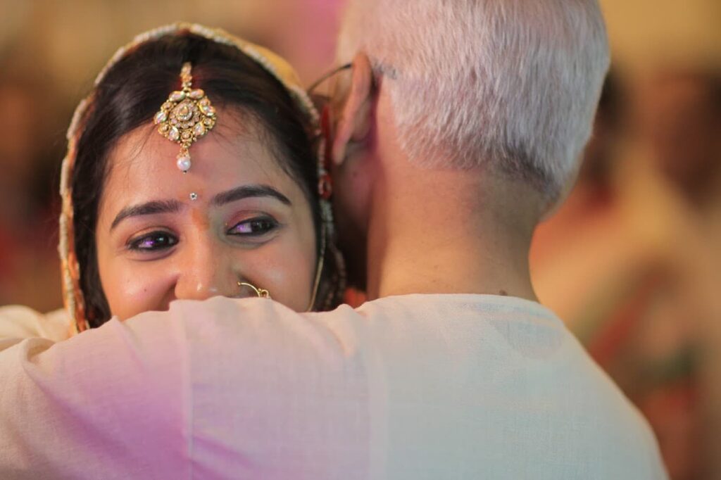 Dr. S.P. Kalantri embracing his daughter Amrita at her Vidai, Nagpur, June 2014. Her face over his shoulder — the moment a daughter leaves her parents' home.