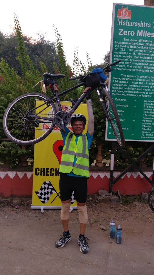 Dr. S.P. Kalantri lifting his bicycle above his head at the Maharashtra Zero Mile marker in Nagpur, at the finish of his 200 km Brevet, November 2016