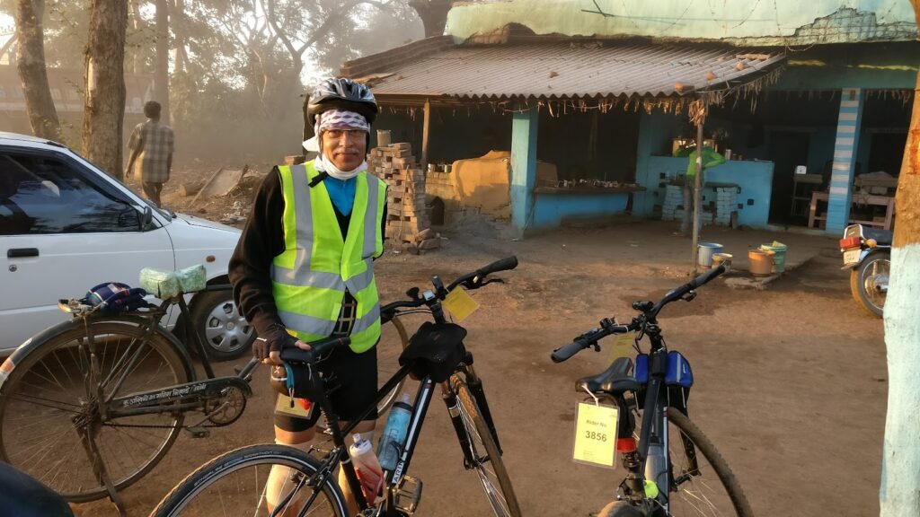 Dr. S.P. Kalantri at a mid-route checkpoint during his 300 km Brevet, December 2016. Race number 3856. Evening light, high-visibility vest, knee supports — still hours from the finish.
