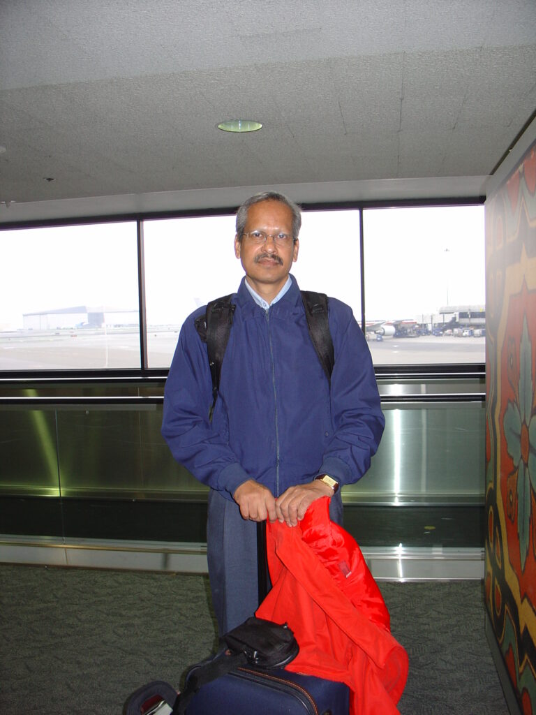 SP Kalantri arriving at San Francisco International Airport, August 2004, with backpack and luggage, to begin his Fogarty-funded MPH at UC Berkeley School of Public Health. Received at the airport by Madhukar Pai.