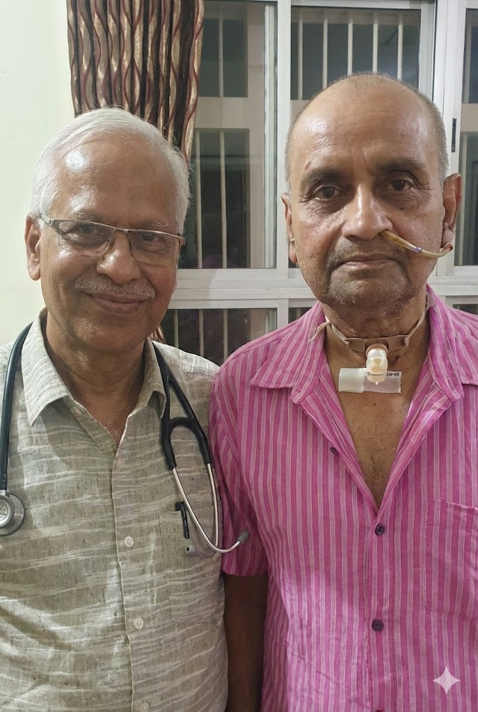SP Kalantri with his childhood friend Sunil Pawar, who developed laryngeal cancer and became his patient, photographed at Sunil's home in Sevagram approximately one month before Sunil's death in 2022. A tracheostomy tube is visible at Sunil's neck.