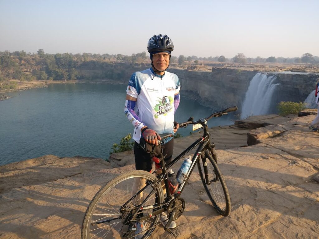 SP Kalantri in Tour de Chhattisgarh cycling jersey with his bicycle at Chitrakote Falls, Chhattisgarh, 2018, during a five-day cycling tour with Ashwini.