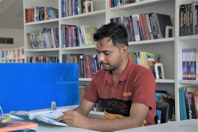 a medical student reading at a desk in the newly renovated MGIMS library, Mahatma Gandhi Institute of Medical Sciences, Sevagram, 2018.