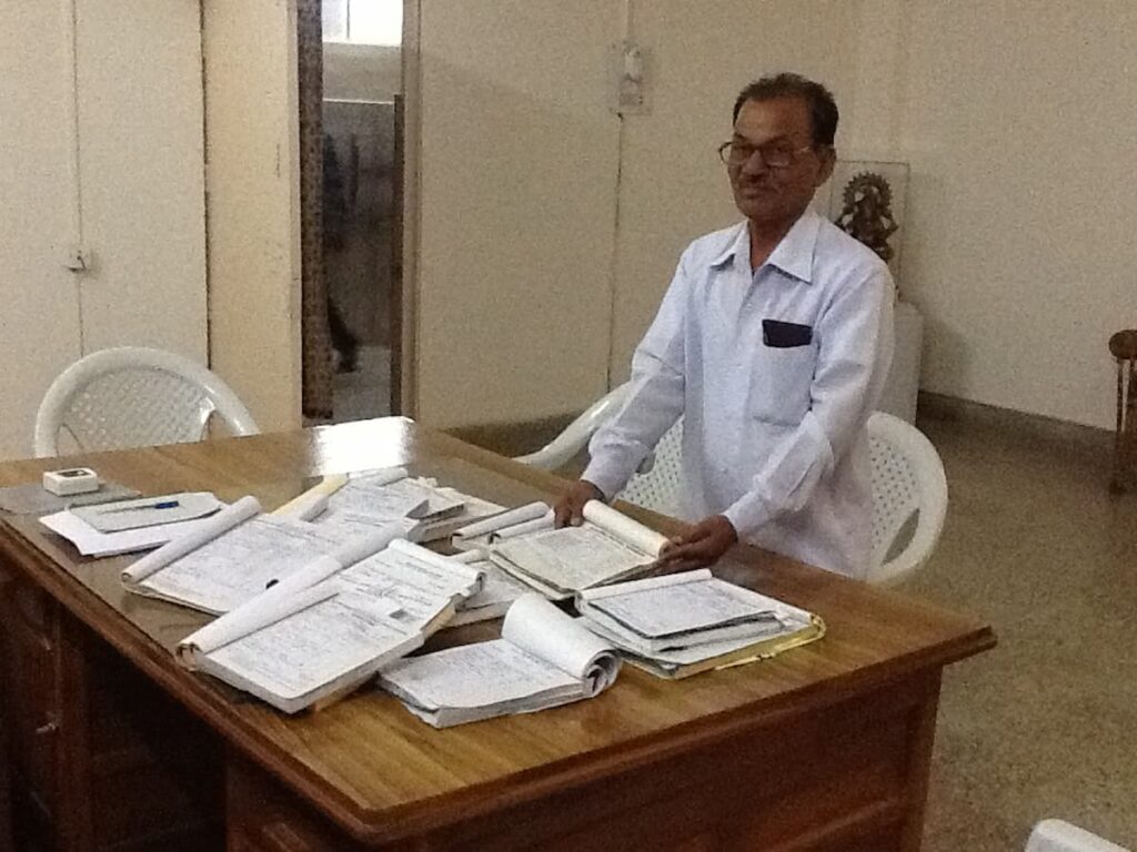 A desk at Kasturba Hospital, Sevagram, buried under registers, files, papers and requisitions awaiting signature — the daily paper burden of hospital administration before the Hospital Information System was introduced in 2009.